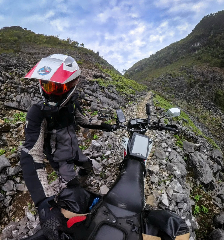 Andrés Sile circulando por una pista de tierra durante su vuelta al mundo en moto