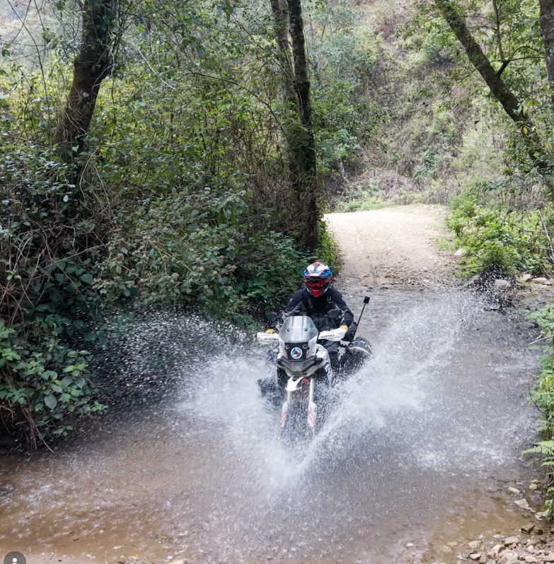 Andrés Sile cruzando un río con la moto en un tramo off-road de su vuelta al mundo