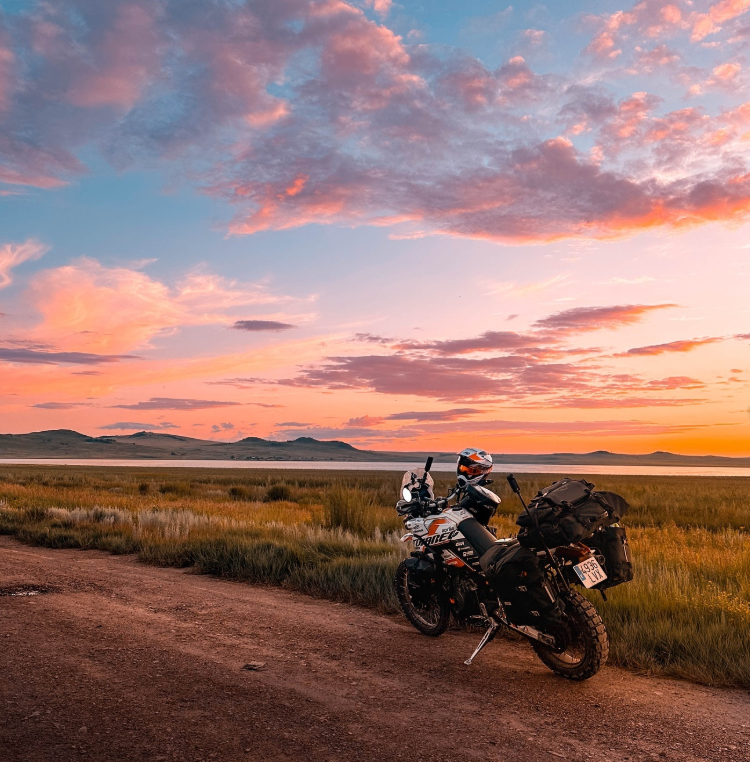Andrés Sile con su moto al atardecer durante su vuelta al mundo en moto